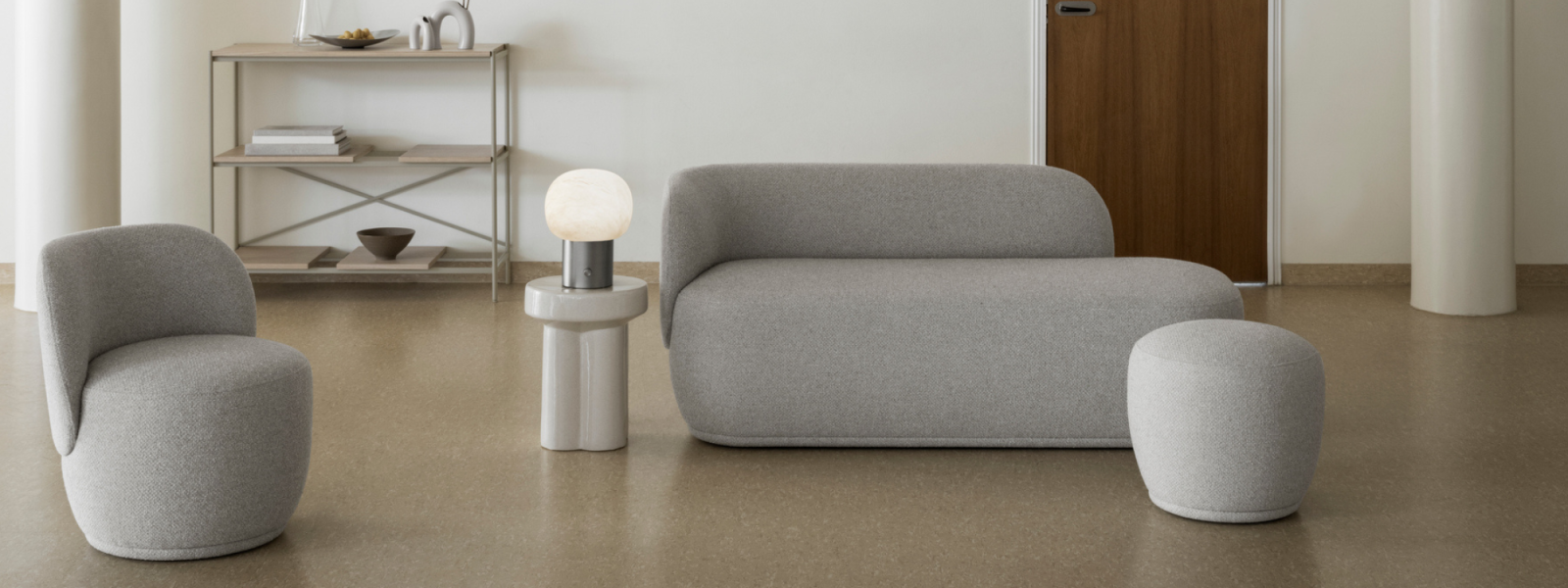 Moderne Wohnräume mit grauem Sofa und minimalistischer Dekoration in neutralen Tönen.