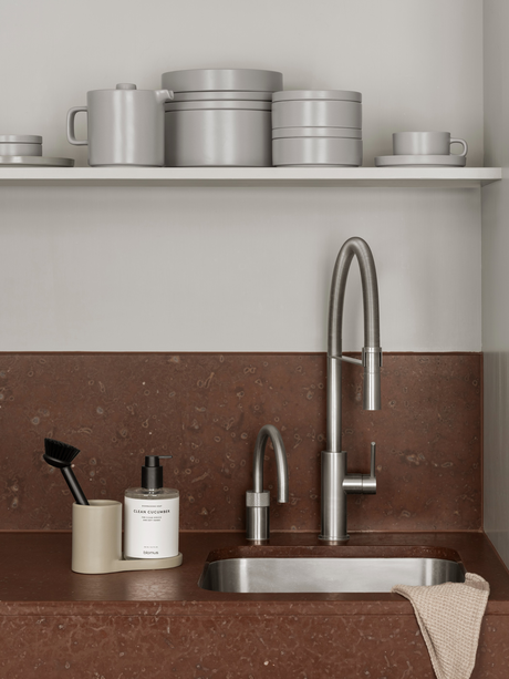 Moderne Küche mit stilvollem Wasserhahn und minimalistischer Dekoration auf rustikalem Naturstein.