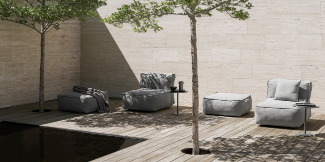 Moderne Lounge-Ecke mit gepolsterten Sesseln und Bäumen in einem eleganten Außenbereich.