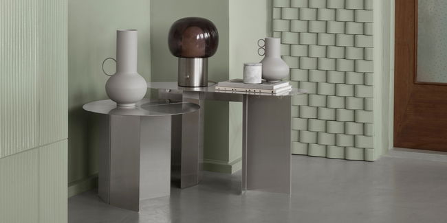 Moderne Beistelltische mit Vasen und Lampe in einem stilvollen Raum.